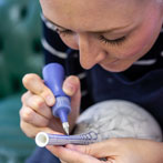 Rhian Malin decorating a mandala bottle in her workshop 2019